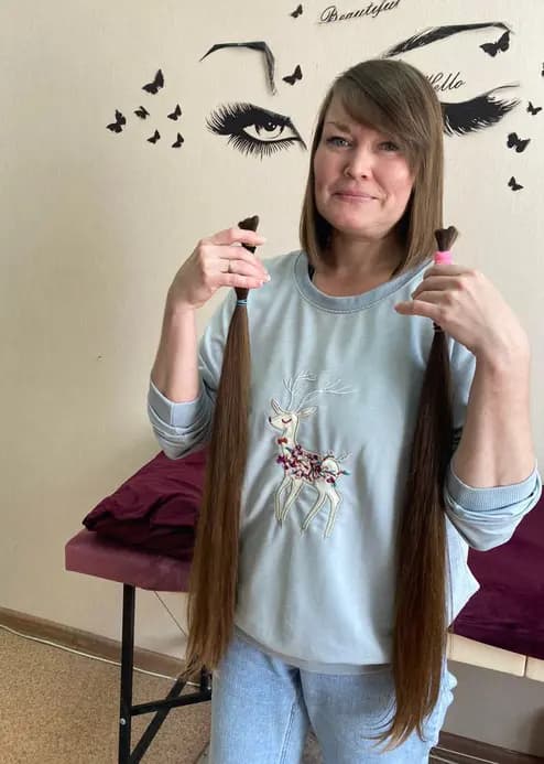 Клиентка показывает длинные срезанные волосы